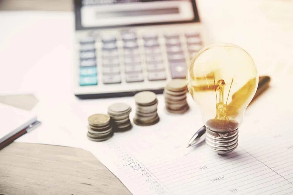 Money calculator and light bulb on financial papers 1920w